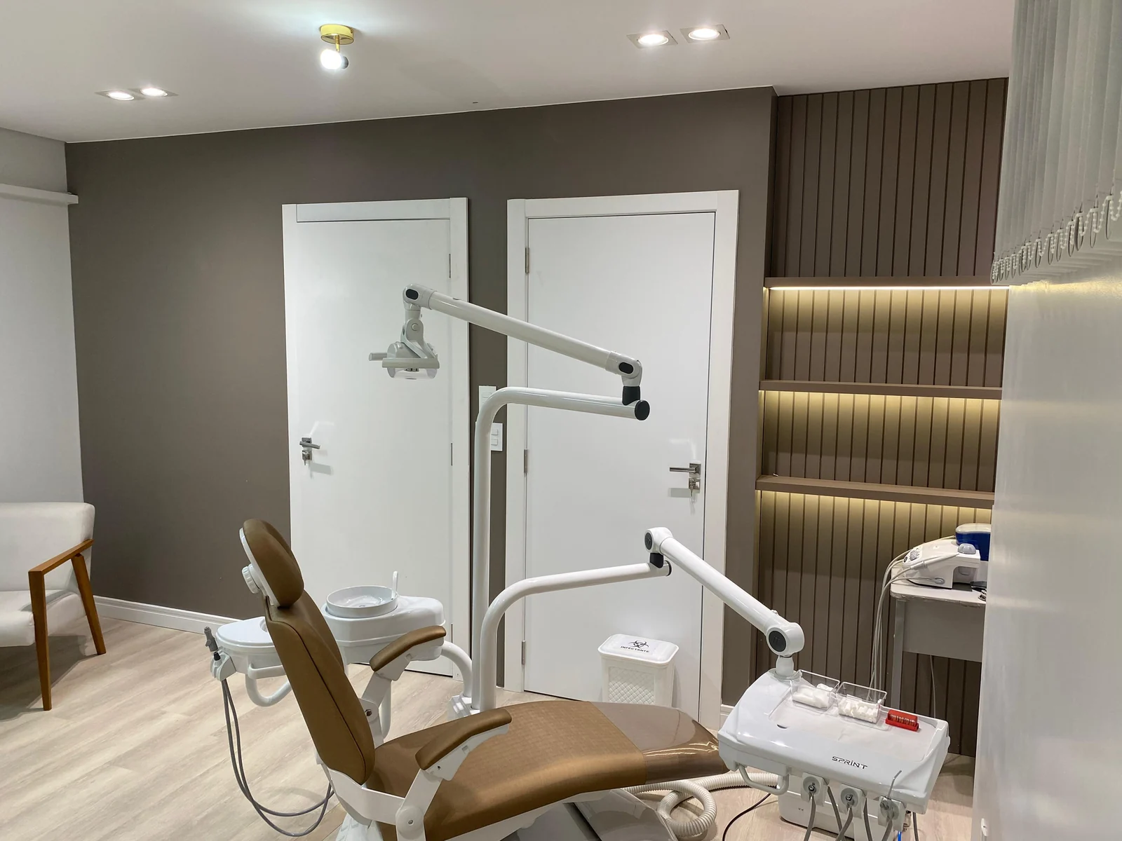 Consultório da FB Odontologia com cadeira odontológica, decoração em madeira e iluminação suave