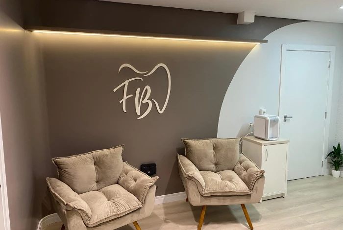 Recepção da FB Odontologia, com poltronas aconchegantes e iluminação acolhedora